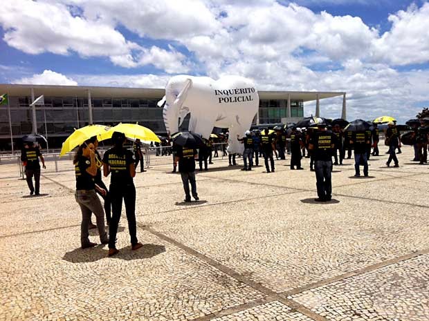 Policiais federais com guarda-chuvas e um elefante inflável fazem ato em frente ao Palácio do Planalto (Foto: Isabella Formiga/G1)