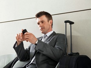 Homem com celular no aeroporto (Foto: Nick White/Image Source/AFP)