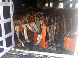 O forro de PVC caiu sobre os bancos da igreja devido ao incêndio  (Foto: Isabella Melo/G1)