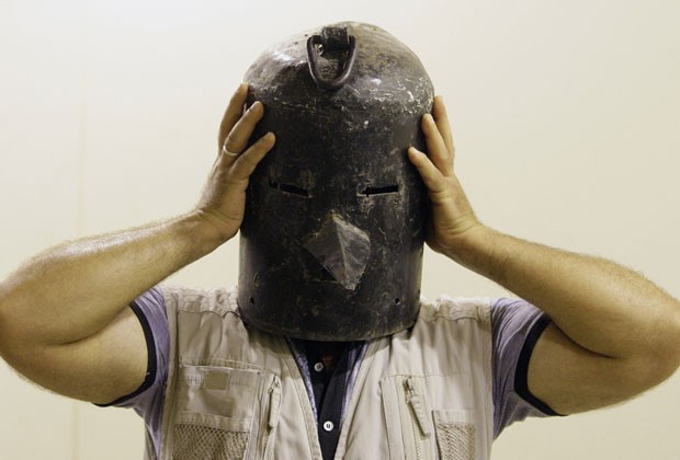 Iraquiano prova máscara de metal usada como objeto de tortura por Saddam Hussein (Foto: Khalid Mohammed/Reuters)