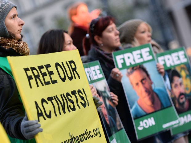 Manifestantes exibem uma faixa com os dizeres “libertem nossos ativistas” em Budapeste, na Hungria, durante protesto contra a prisão de integrantes do Greenpeace na Rússia em uma manifestação realizada neste sábado (16) (Foto: AFP Photo/Attila Kisbenedek)