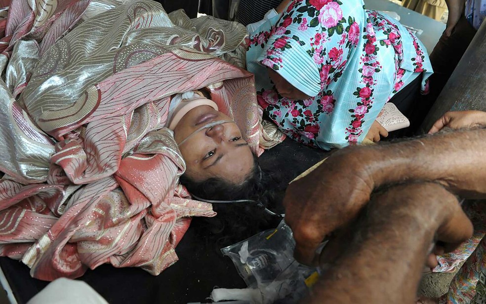 Sobrevivente retirado de escombros em um hospital da província de Aceh (Foto: Chaideer Mahyuddin / AFP Photo)