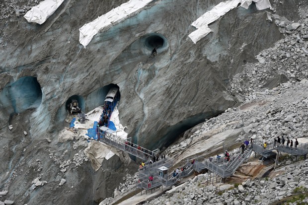  Visitantes passam por passarelas ao visitar a "Caverna de Gelo", na geleira "Mar de Gelo", no Mont-Blanc (Foto: AFP Photo/Philippe Desmazes)