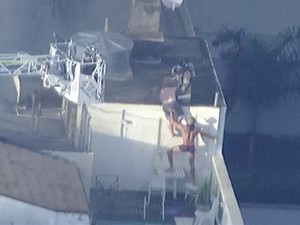Duas pessoas foram flagradas no topo do prédio atingido por incêndio (Foto: Reprodução/TV Globo)