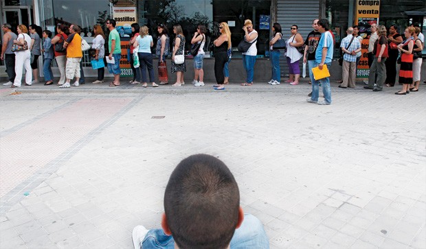 POUCA ESPERANÇA  Um jovem vê uma fila de espanhóis em busca de trabalho em Madri. O desemprego na Espanha bate na casa dos 25% (Foto: Susana Vera/Reuters )