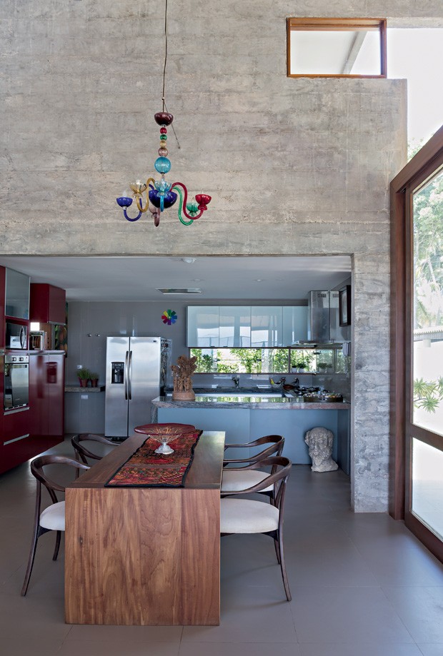 Sala de jantar | A cozinha fica no bloco de concreto e é aberta para o living. Os armários da Florense têmacabamento de laca brilhante em contraste com o piso de porcelanato, que imita cimento (Foto: Fotos e produção Projeto Sertões)