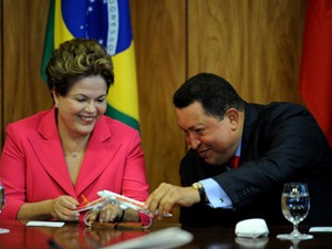 Dilma Rousseff e Hugo Chávez brincam com aviões em miniatura durante assinatura de acordo (Foto: PEDRO LADEIRA / AFP)