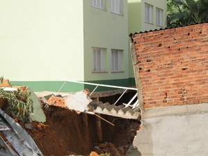 Parte do muro de contenção cedeu e causou abalos em três construções (Foto: Carlos Santos/G1)