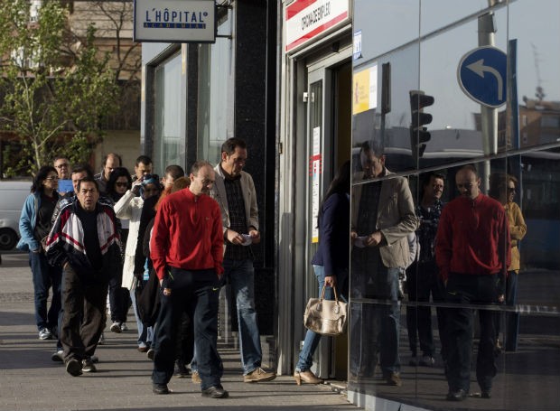 Espanhóis fazem fila na porta de uma agência de empregos em Madri (Foto: Paul White/AP)