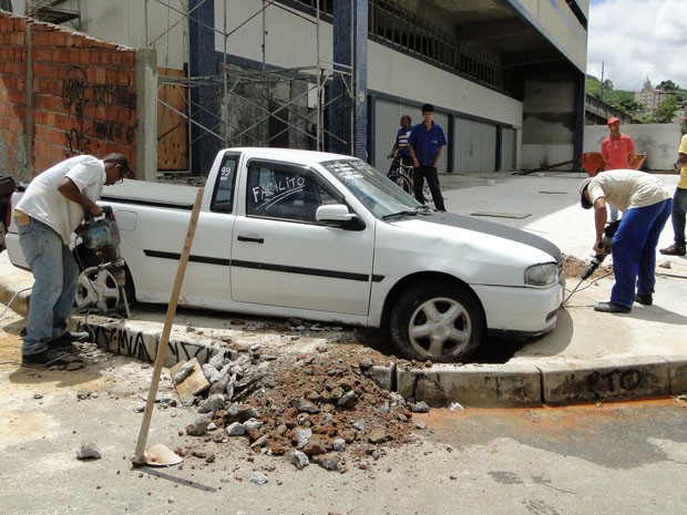 Trabalhadores de obra removeram cimento das rodas do carro, na Avenida Barão Homem de Melo. (Foto: Flávia Cristini/ G1)