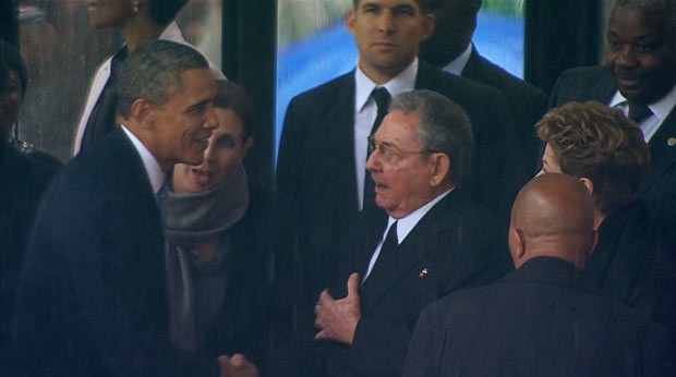 Observado por Dilma, os presidentes dos EUA, Barack Obama, e de Cuba, Raúl Castro, se cumprimentam nesta terça-feira (10) em homenagem a Mandela (Foto: Reuters)