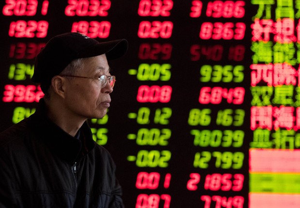 Investidor observa painel na Bolsa de Valores de Xangai ; ações chinesas ; mercado financeiro asiático ;  (Foto: ChinaFotoPress/Getty Images)