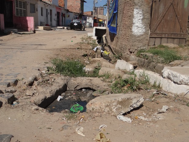 Esgoto a céu aberto e calcamento danificado pode ser visto em todo bairro (Foto: Marcio Chagas/G1)