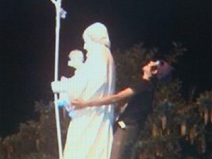 Foto publicada em rede social mostra jovem de 19 anos fazendo gesto obsceno atrás de santo (Foto: Ronaldo Oliveira/ EPTV)