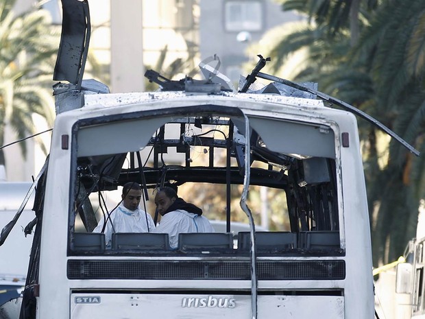 Polícia forense inspeciona um ônibus da guarda presidencial que foi alvo de um ataque suicida com bomba em Túnis. Pelo menos 13 pessoas foram mortas. O governo anunciou estado de emergência em todo o território (Foto: Zoubeir Souissi/Reuters)