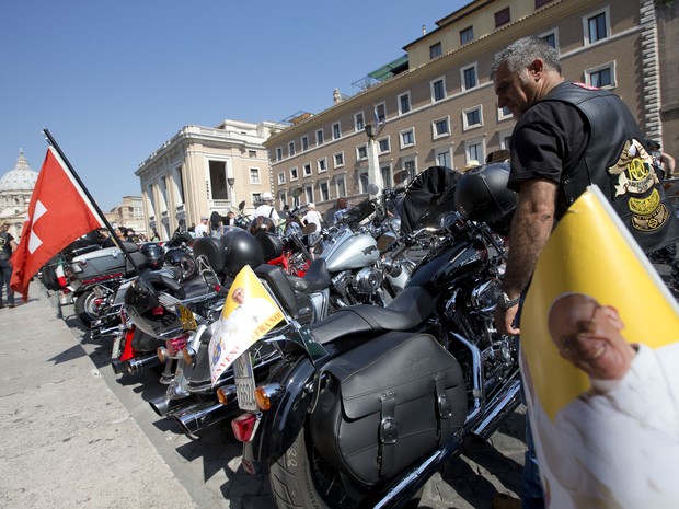 Motociclistas utilizam bandeiras com a imagem do Papa Francisco, no Vaticano, neste domingo (16) (Foto: AP Photo/Andrew Medichini)