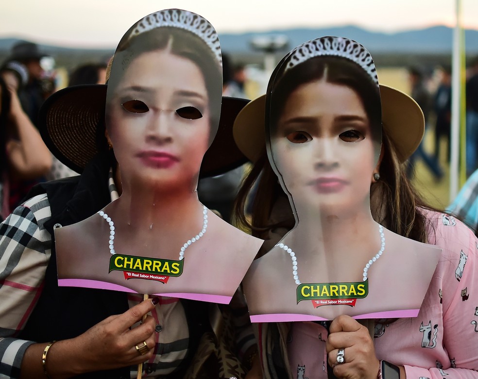 Pessoas circulavam pelo local com máscaras do rosto da aniversariante (Foto: RONALDO SCHEMIDT / AFP)