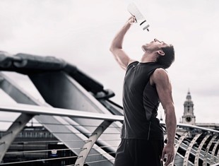 Homem após corrida bebendo água com squeeze (Foto: Getty Images)