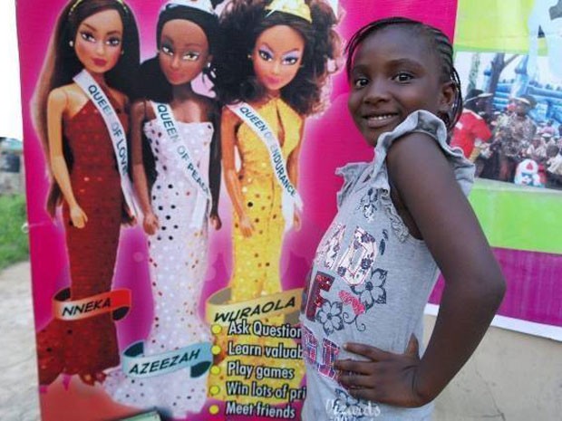 Criança em frente a caixas com as bonecas (Foto: Queens of Africa/Divulgação)