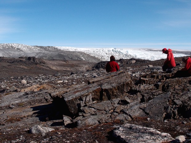 Em foto de julho de 2012, cientistas examinam rochas na Groenlândia, onde teria sido encontrado o mais antigo fóssil do mundo, com 3.7 bilhões de anos (Foto: Laure Gauthiez/The Australian National University via AP)