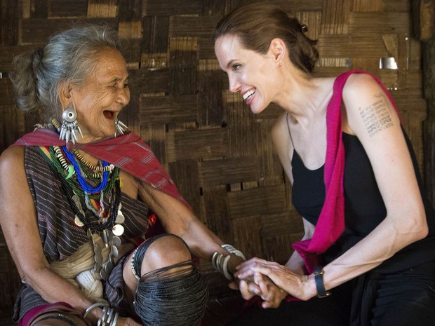 Enviada especial do Alto Comissariado da ONU para Refugiados, Angelina Jolie (dir.) conversa com a refugiada Baw Meh, de 75 anos, de Mianmar, no acampamento de Ban Mai Nai Soi, na Tailândia, perto da fronteira. A idosa vive no acampamento há 18 anos (Foto: Roger Arnold/ UNHCR/AFP)