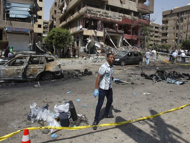 Policial à paisana inspeciona local de explosão perto da casa do ministro do Interior do Egito, Mohamed Ibrahim, em Nasr, no Cairo. O ministro sobreviveu ao atentado, que usou uma bomba acionada por controle remoto. (Foto: Amr Abdallah Dalsh/Reuters)