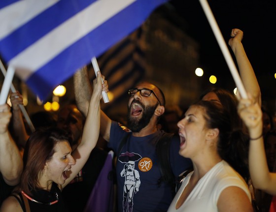 Gregos que votaram contra acordo proposto por credores comemoram resultado do referendo em Atenas, na Grécia (Foto: AP Photo/Emilio Morenatti)