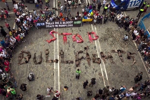 Grupo faz protesto contra a tourada nesta quinta (5) na Espanha. Os manifestantes se pintaram de vermelho e preto e formaram a frase ‘parem com a tourada’. No dia 6, o festival de tourada San Fermin começa em Pamplona, durando uma semana (Foto: Reuters)