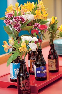 Não só garrafas de vinho viram vasos para flores. As de cerveja também podem desempenhar bem este papel. Elas podem voltar à mesa com os rótulos coloridos e diferentes