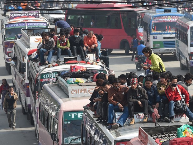 Nepaleses viajam em cima de ônibus enquanto saem de Catmandu, no Nepal, temendo uma epidemia ou novos tremores. O número de mortos no terremoto já passa de 4 mil, segundo as autoridades locais (Foto: Prakash Singh/AFP)