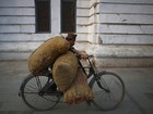 Homem leva bicicleta 'supercarregada' de batatas no Nepal
