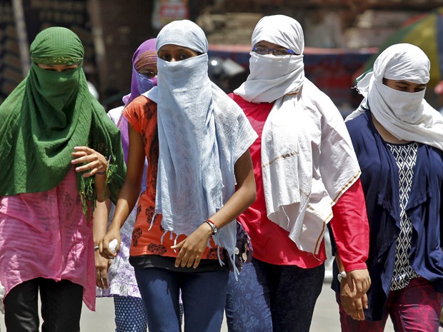 Mulheres se protegem do sol en Allahabad, na Índia (Foto: Reuters)