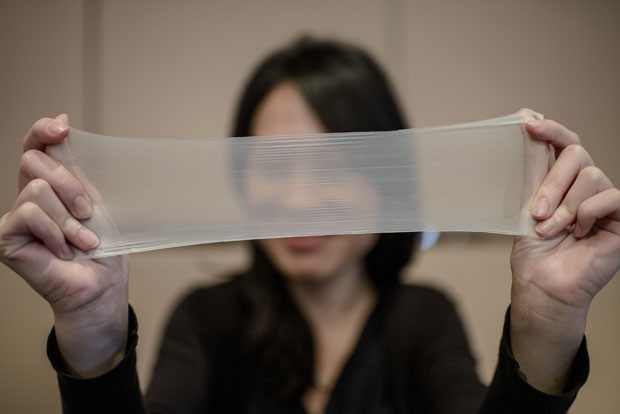 Funcionária da Guangzhou Daming United Rubber Products Limited demonstra elasticidade do látex usado nas camisinhas (Foto: Philippe Lopez/AFP)