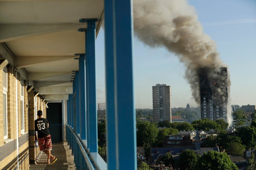 Morador observa de longe o incêndio em prédio no oeste de Londres (Foto: Matt Dunham/AP)