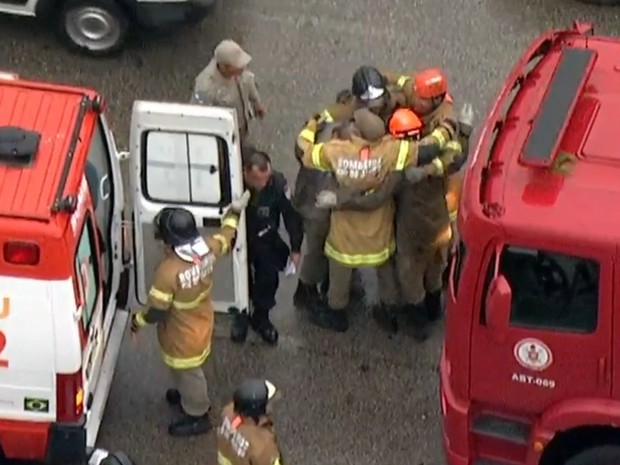 Bombeiros comemoram resgate de vítima de acidente na Avenida Brasil (Foto: Reprodução/ TV Globo)