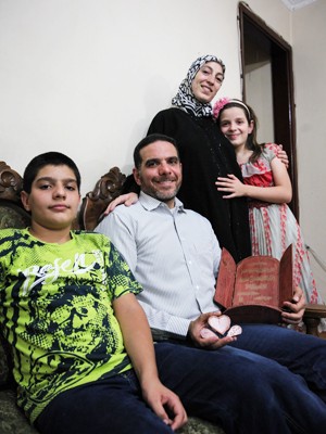 Talal Al Tinawi posa para foto com a família na sala de sua casa, no Brás (Foto: Fábio Tito/G1)