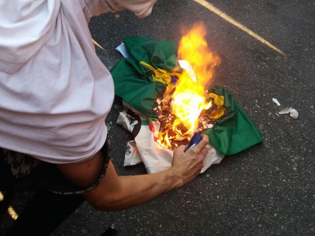 Manifestantes queimam bandeiras do Brasil e dos Jogos Olímpicos durante protesto na Tijuca (Foto: Alessandro Ferreira/G1)