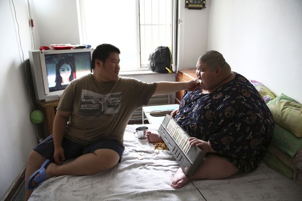 O chinês Zhang Hangjun, de 20 anos, sofre de paralisia cerebral e pesa 250 kg. Segundo a agência Reuters, ele vive com a família, incluindo um irmão gêmeo (que está na foto) também diagnosticado com danos cerebrais. Os dois moram em Shenyang, na província de Liaoning, na China. (Foto: Reuters/Stringer)
