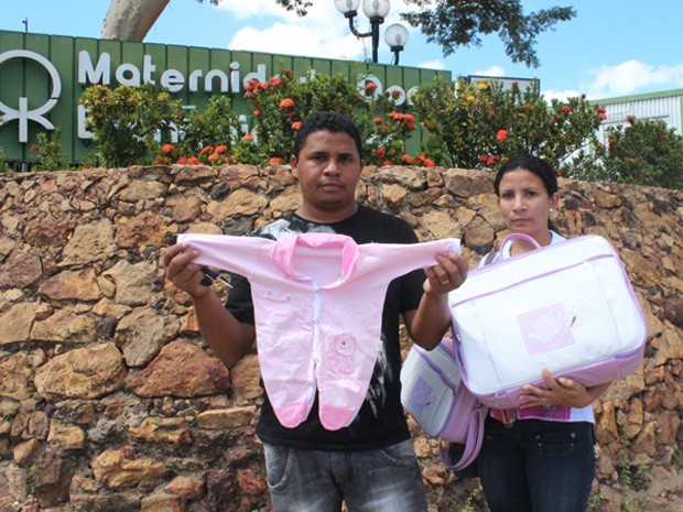 Sildane da Silva ao lado da irmã mostram parte do enxoval do bebê (Foto: Gilcilene Araújo/G1)