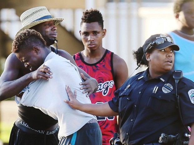 Pessoas choram e se abraçam em frente à boate Club Blu em Fort Myers, na Flórida (EUA), onde um tiroteio no estacionamento deixou dois mortos e 14 feridos (Foto: Kinfay Moroti/The News/AP)