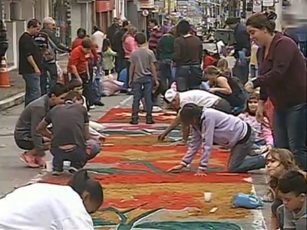 Centenas de católicos trabalham na confecção do tapete de Corpus Christi na região (Foto: Reprodução/TV Tem)