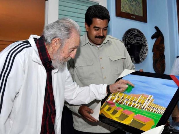O presidente da Venezuela, Nicolás Maduro, ao lado do líder cubano Fidel Castro, neste sábado (27), em Havana. Eles observam quadro pintado pelo falecido presidente venezuelano Hugo Chávez (Foto: AP)
