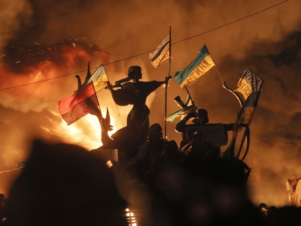 18/2 - Manifestantes colocam fogo em barricada durante confronto próximo ao monumentos aos fundadores de Kiev. (Foto: Efrem Lukatsky/AP)