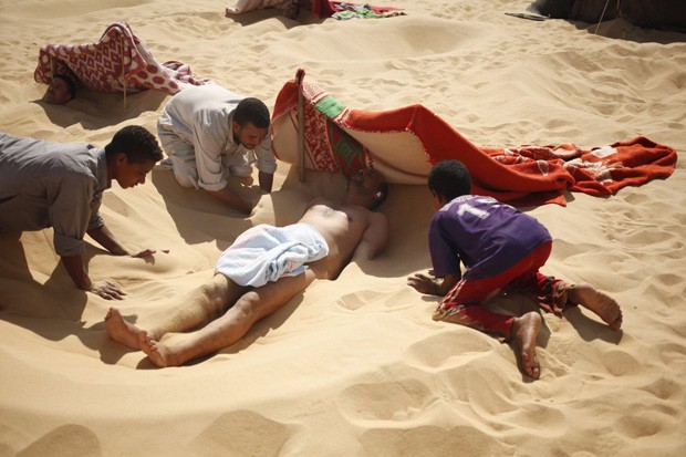 No Egito, banho de areia quente é tradicional (Foto: Reuters/Asmaa Waguih) No Egito, banho de areia quente é tradicional (Foto: Reuters/Asmaa Waguih)