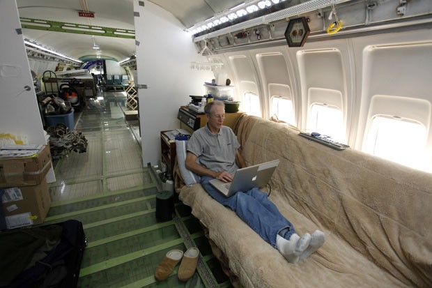 O americano Bruce Campbell senta no futon usado como sua cama dentro do Boeing 727 que ele restaurou e transformou em sua casa (Foto: Steve Dipaola/Reuters)