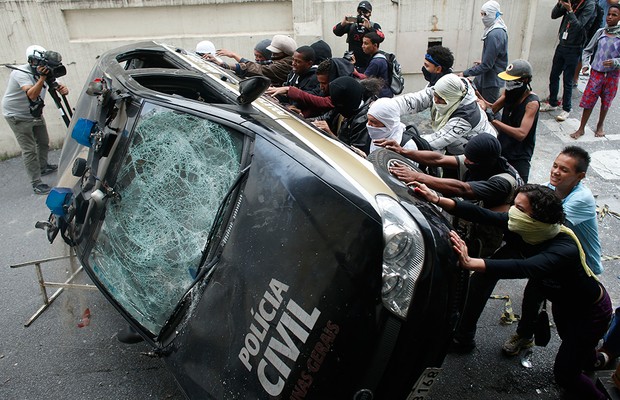 Manifestantes viram carro da Polícia Civil em Belo Horizonte  (Foto: AP Photo/Victor R. Caivano)