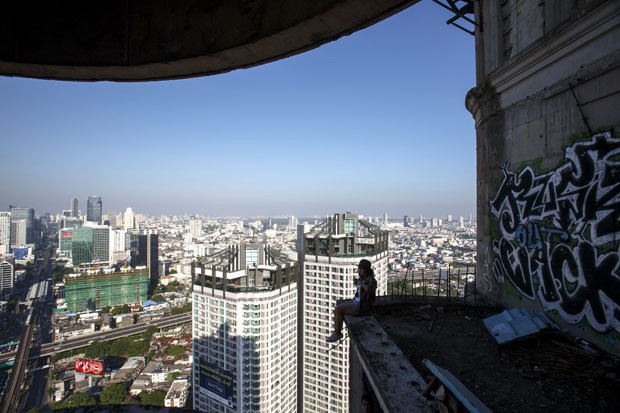 Turista sentada em um dos 49 andares da Torre Fantasma (Foto: Athit Perawongmetha/Reuters)