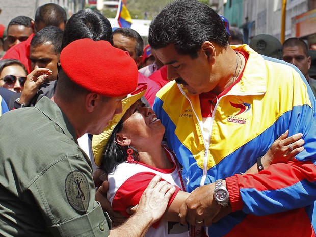 Mulher conversa com o vice-presidente Maduro durante cortejo de Hugo Chávez (Foto: Carlos Garcia Rawlins/Reuters)