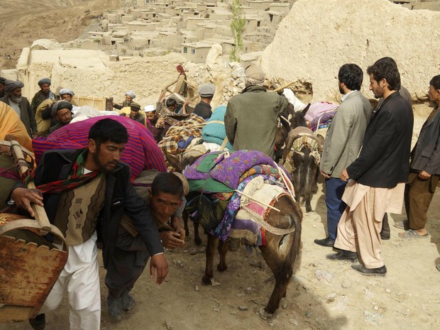 Moradores do vilarejo província de Badakhshan caminham com seus pertences neste sábado (3) (Foto: Stringer/Reuters)