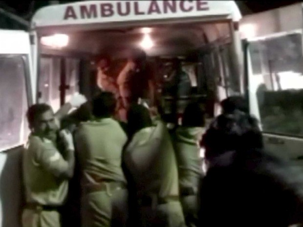 Policiais levam feridos para uma ambulância após incêndio e explosão em templo na Índia (Foto: ANI / via Reuters)